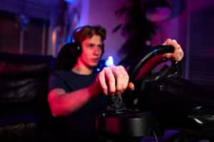 Pilote casque sur les oreilles, une main sur le levier de vitesse et une sur le volant, cockpit éclairé en bleu et violet