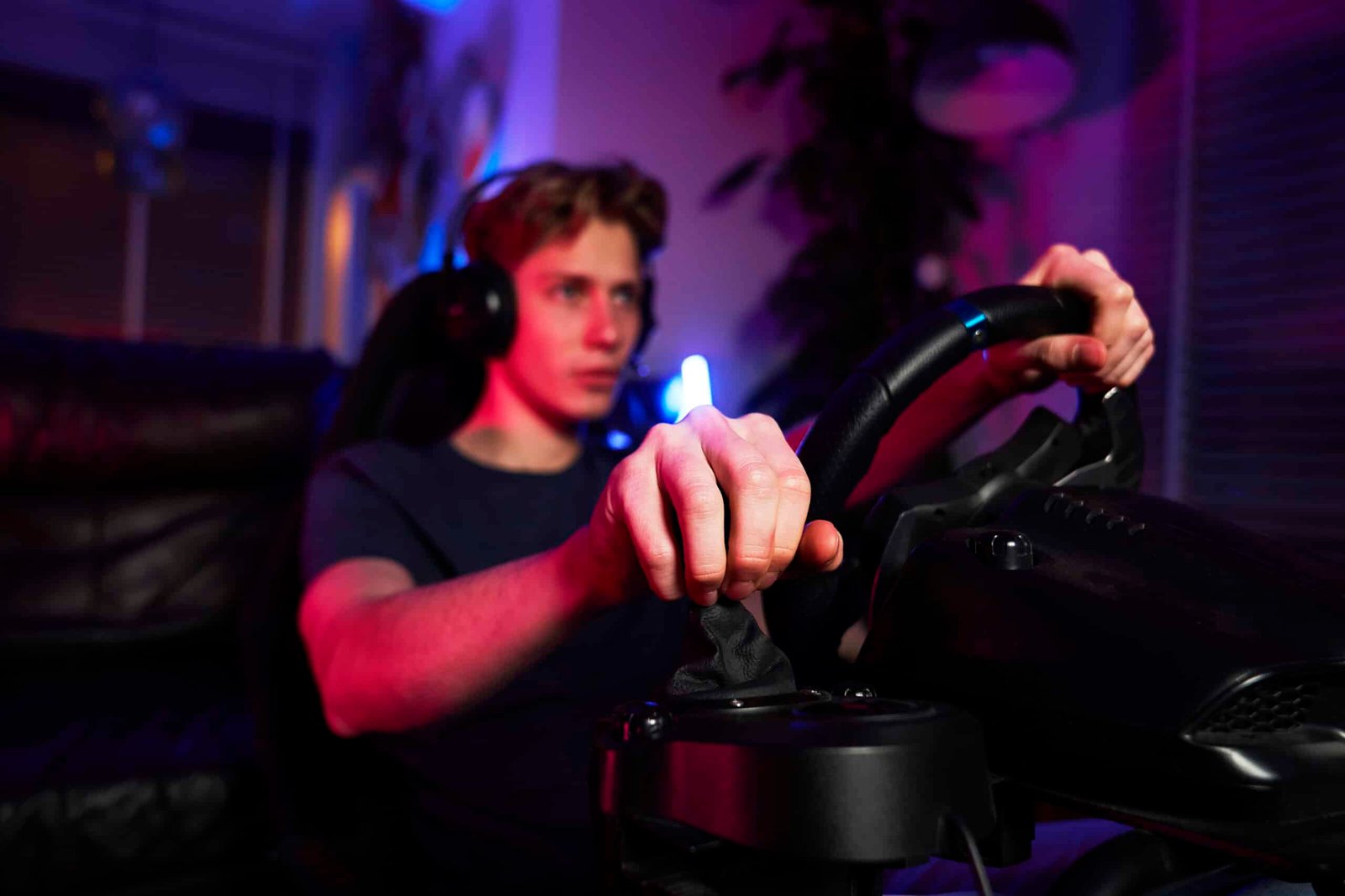 Pilote casque sur les oreilles, une main sur le levier de vitesse et une sur le volant, cockpit éclairé en bleu et violet