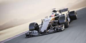 Monoplace de course sombre lancée à pleine vitesse sur l'asphalte d'un circuit, arrière-plan flou de vitesse